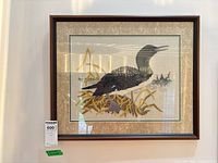 Full view of framed embroidered loon artwork on wall