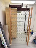Full view of wooden-frame wine rack with metal shelves and two trays on top