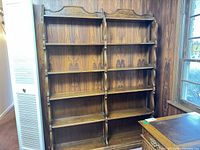 Front view of entire bookcase against panel wall