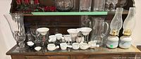 Full view showing glassware, ceramic butter warmers and stands on hutch shelf