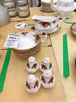 stack of berry bowls, gravy boat on underplate, four shakers visible