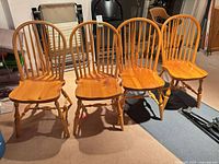 Front view of four matching pine spindle-back chairs