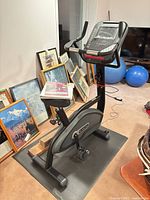 Full view of Star Trac 4-UB upright exercise bike on mat