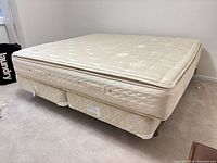 Mattress set on frame, quilted pillowtop visible