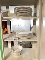 Shelved stacks of larger plates, smaller plates and bowls