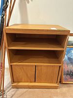 Front view of wood cabinet showing open shelf and lower sliding doors