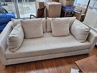 Front view of grey upholstered sofa with five cushions