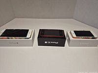 Three boxed iPhones displayed side by side