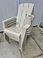 Stacked beige plastic Muskoka chairs