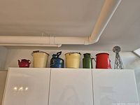 All five vintage containers lined up on cabinet top