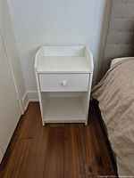 Nightstand left side of bed showing drawer and shelf