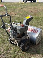Left side view of Craftsman 8/24 snow blower showing engine, controls and tires