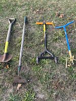 All four garden tools laid out on grass