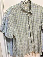 Front view of yellow-blue plaid shirt with others layered behind