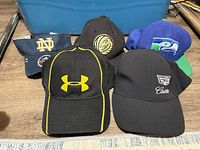 Five baseball caps laid out showing logos