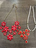 Red floral cabochon bib, red cabochon pendant, white bead strand