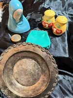 Group view of platter, shakers, figurine, compact, coin purse, stand