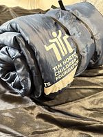 Rolled navy blue sleeping bag with Tim Hortons Children’s Foundation logo visible