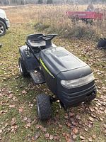Front left view of Poulan riding mower showing body and damaged left front wheel