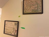 Two framed map posters on wall