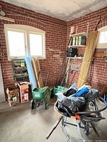 View of garage showing two Scotts spreaders, blue foam roll, stakes, accessories