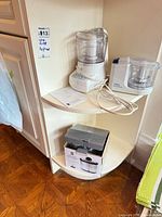 Shelf showing both mini food processors, instruction sheet and boxed mini cooker