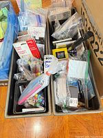 Overall view of two metal trays filled with bagged office and craft supplies