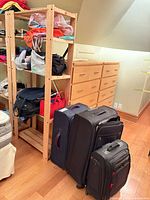 Overall view of three suitcases and shelf holding tote bags
