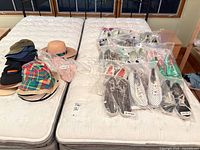 Shoes bagged in clear plastic and stacked hats on mattress