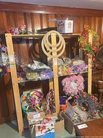 Front view of wooden shelving unit with four shelves holding various craft items