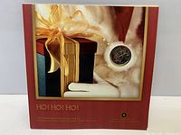 Front cover of holiday coin set showing gift graphics and one coin visible