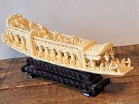 full left-side view of carved boat on stand