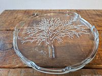 Top view of round glass plate with tree relief and signature