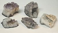 Group of five amethyst clusters on white background