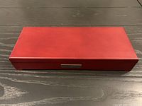 Closed red-burgundy wooden presentation box on table