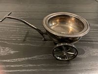 side view showing wheelbarrow shape, wheels, handle