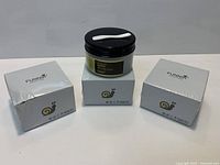 Three product boxes and one jar with applicator spoon