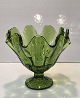 Full view of green glass footed compote showing ruffled rim and fluted body