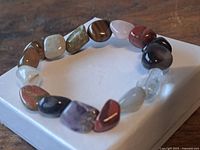 Bracelet laid flat displaying variety of polished stone beads on stretch cord