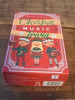 Front view of red Christmas Music Trivia card game box