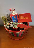 Overall view of basket filled with assorted ornaments including boxed items and MMA card