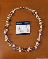 Necklace arranged in oval with earrings on display card