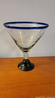 Front view of oversized margarita glass showing clear bowl with blue rim and blue foot