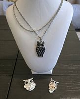 Necklace displayed on bust with two brooches beneath