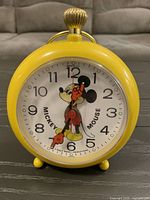 Front view of yellow Bradley Mickey Mouse alarm clock showing dial and character graphic