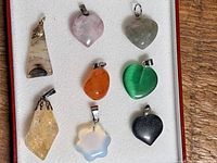 Eight assorted stone pendants arranged in box