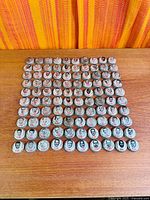 Square layout of all 100 caps on wood surface