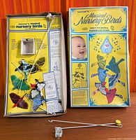 Open box showing birds, rods, bracket, instructions