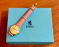 Front view of Omega Genève watch on blue Birks box