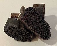Front and side view of two carved blocks showing paisley and vine patterns